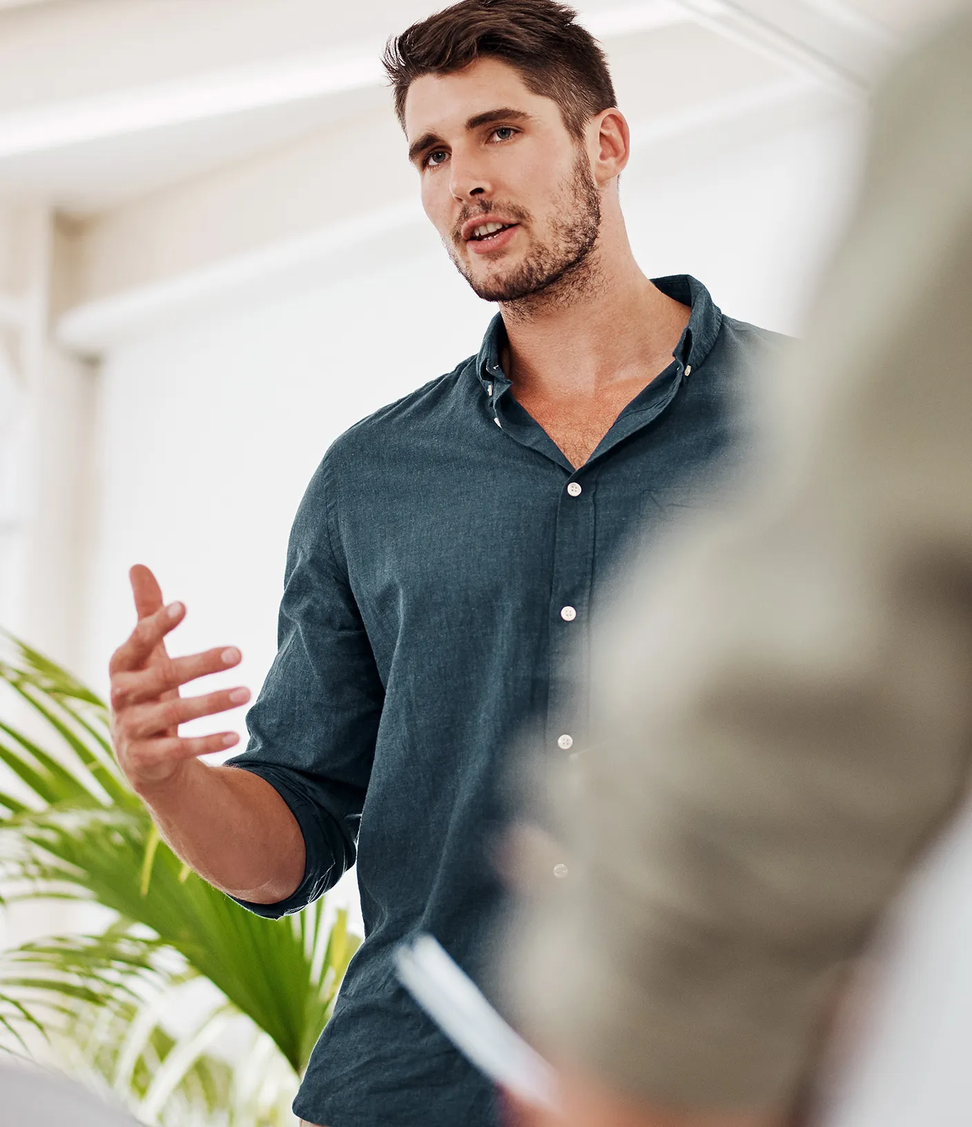 Mann mit grauem Hemd pr&auml;sentiert etwas